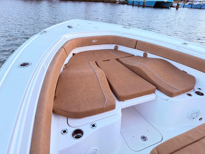 Slide: The Image of 2023 Sea Hunt Ultra 305 SE boat with tan seating, docked on calm water. - 12