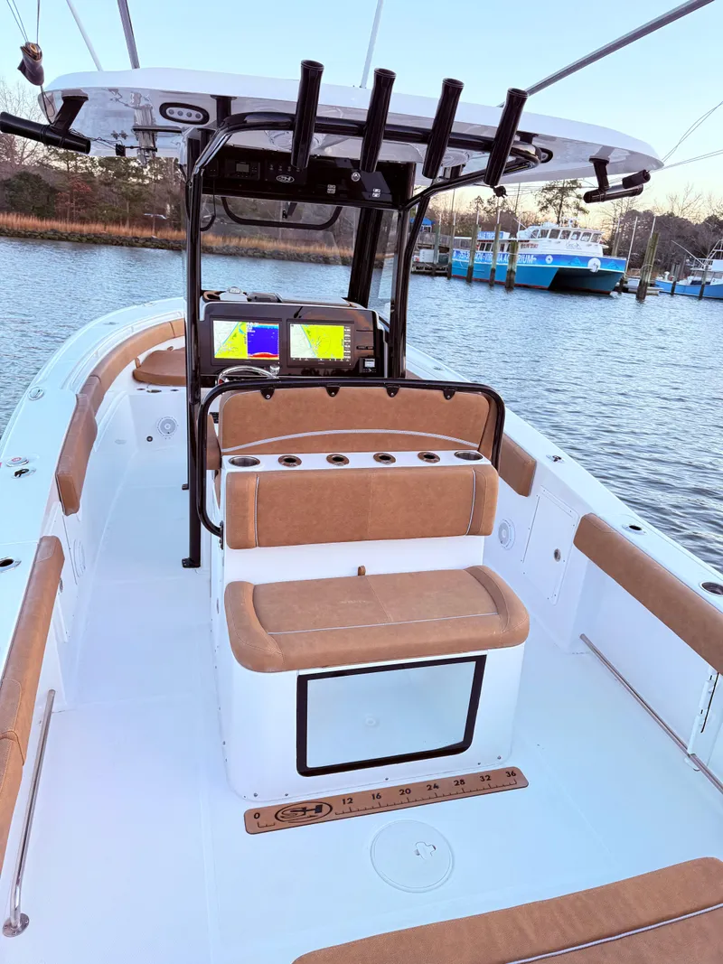 Slide: The Image of 2023 Sea Hunt Ultra 305 SE boat interior with seating and navigation equipment. - 14