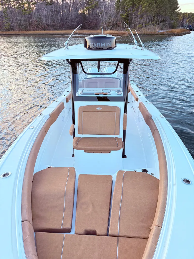 Slide: The Image of 2023 Sea Hunt Ultra 305 SE boat on calm water, featuring spacious seating and modern design. - 15