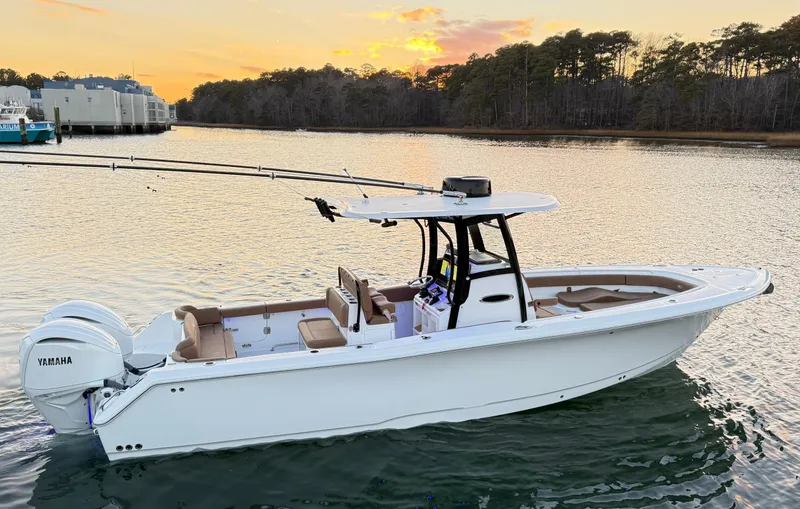 Slide: The Image of 2023 Sea Hunt Ultra 305 SE boat on calm water at sunset. - 2