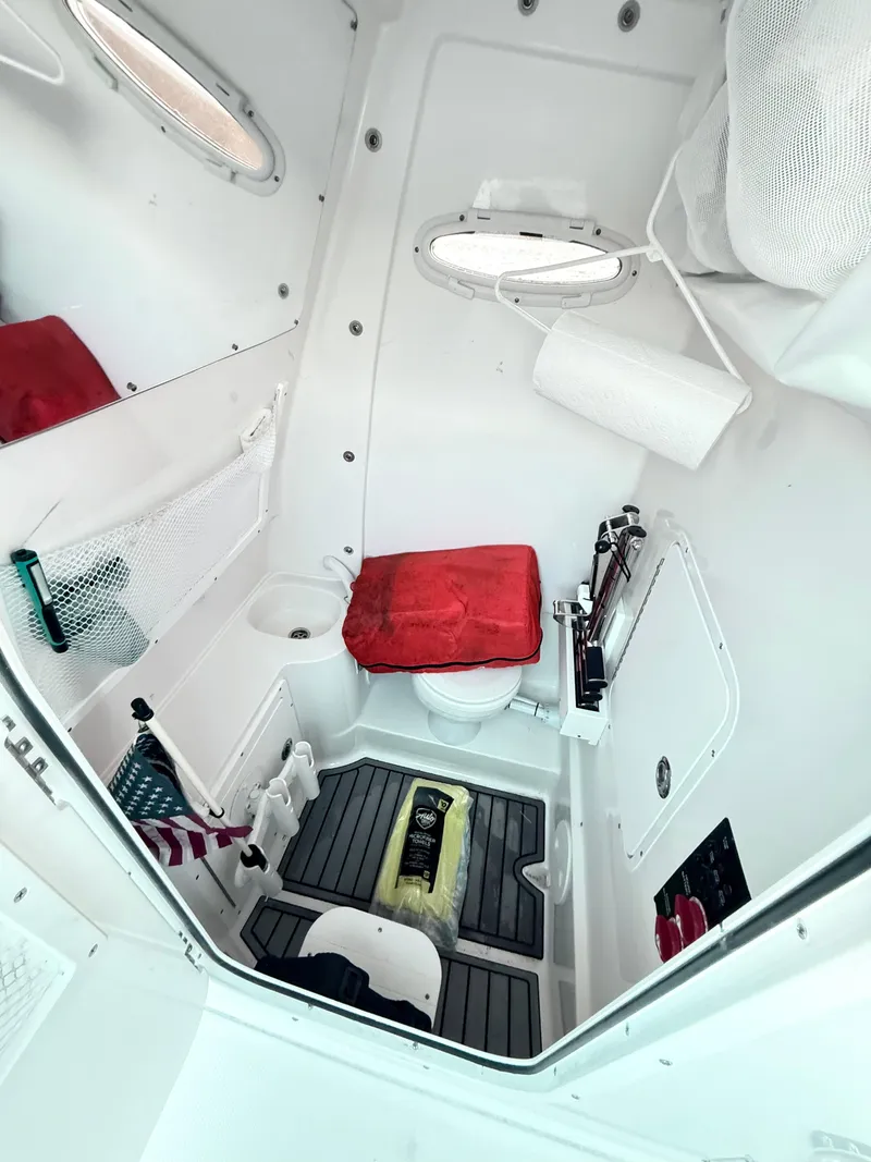 Slide: The Image of Interior of 2023 Sea Hunt Ultra 305 SE boat, featuring compact bathroom amenities. - 22