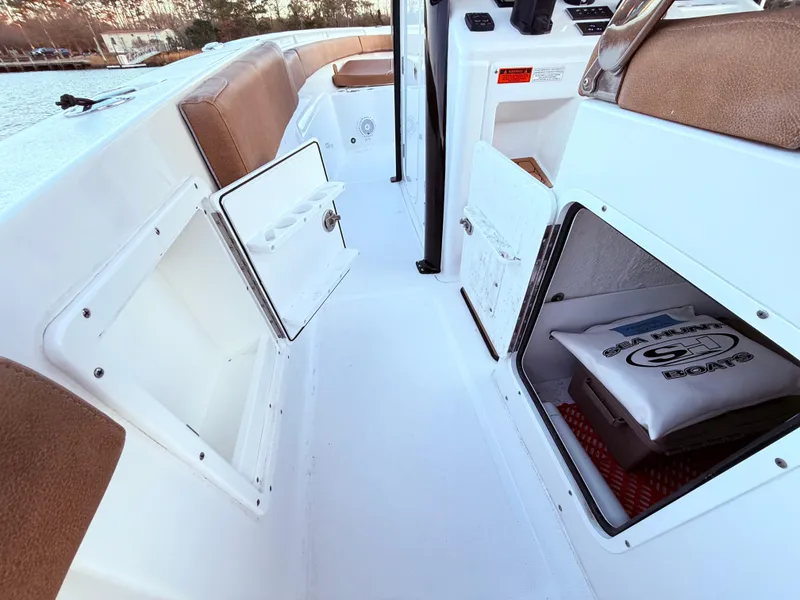 Slide: The Image of 2023 Sea Hunt Ultra 305 SE boat interior with open storage compartments. - 28