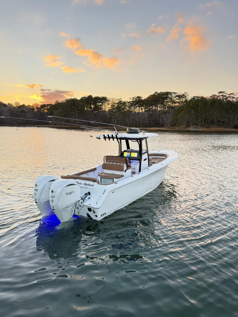 Slide: The Image of 2023 Sea Hunt Ultra 305 SE boat on calm water at sunset. - 3