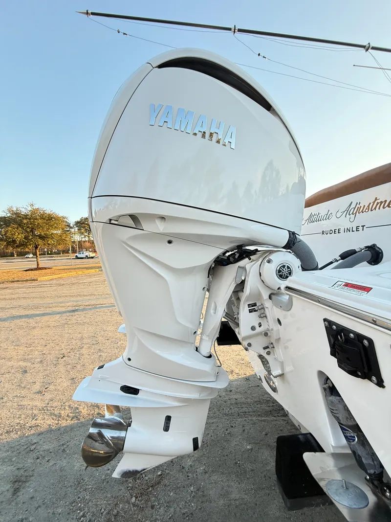 Slide: The Image of 2023 Sea Hunt Ultra 305 SE boat with Yamaha outboard motor, parked on gravel. - 34