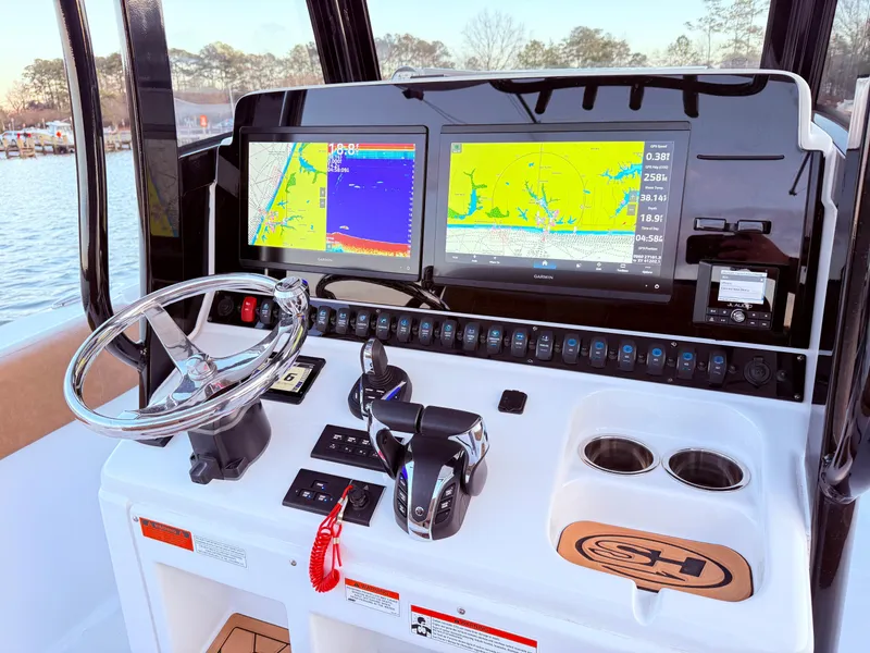 Slide: The Image of 2023 Sea Hunt Ultra 305 SE dashboard with dual navigation screens and steering wheel. - 5