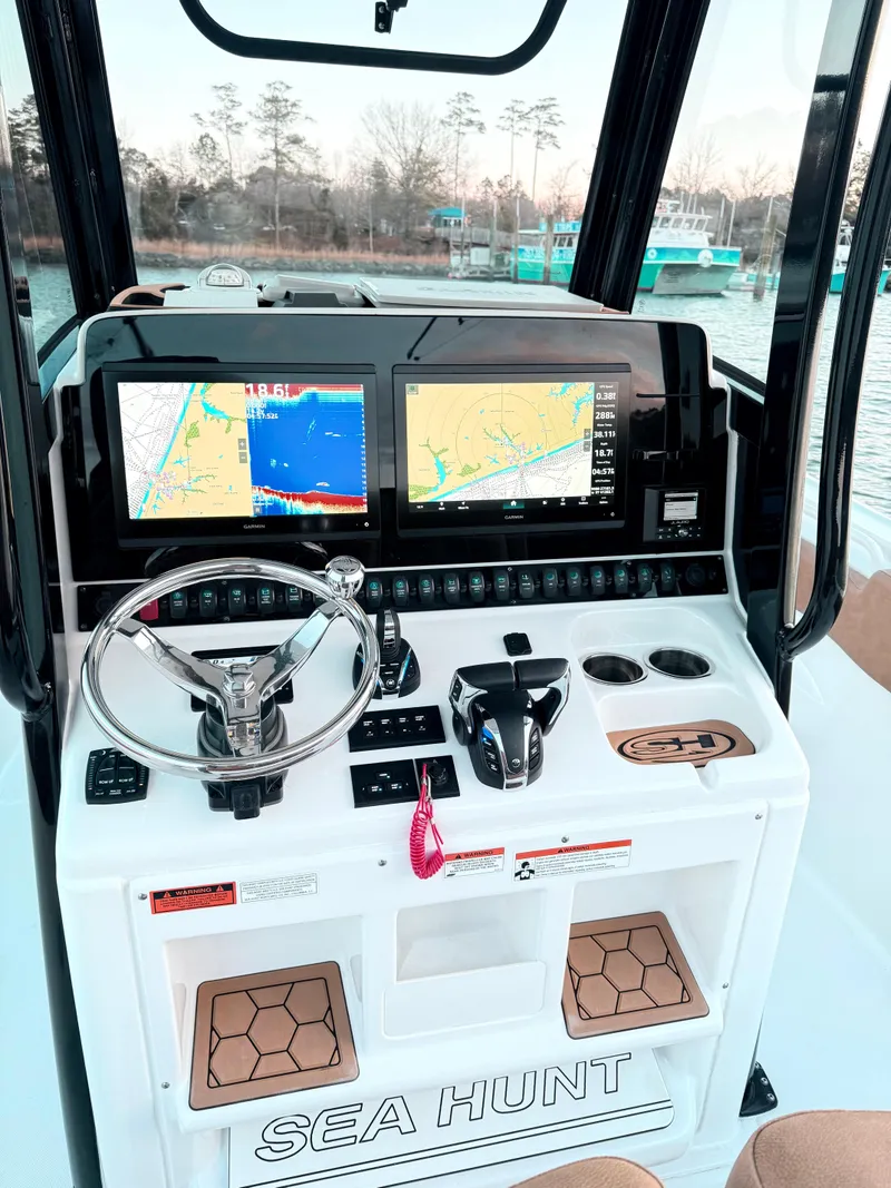 Slide: The Image of 2023 Sea Hunt Ultra 305 SE boat dashboard with navigation screens and controls. - 8