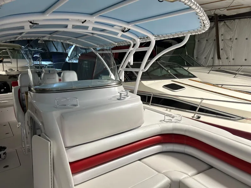 The Image of 2007 Donzi 38 ZF Cuddy boat interior with white and red seating, under a blue canopy. - 0
