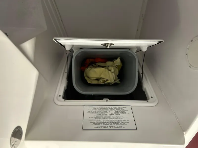 Slide: The Image of Storage compartment in a 2007 Donzi 38 ZF Cuddy boat, containing a bin with items. - 5