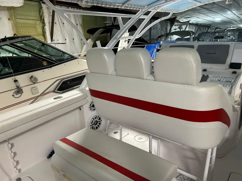 Slide: The Image of 2007 Donzi 38 ZF Cuddy boat interior with white and red seating, docked indoors. - 6