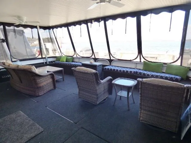 Slide: The Image of Spacious sunroom with wicker furniture on a Thoroughbred 20x90 houseboat, 2006 model. - 1