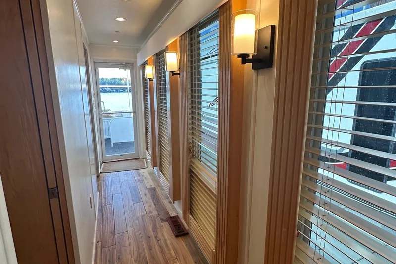 Slide: The Image of Narrow hallway in 2006 Thoroughbred 20x90 houseboat with wooden flooring and wall sconces. - 13