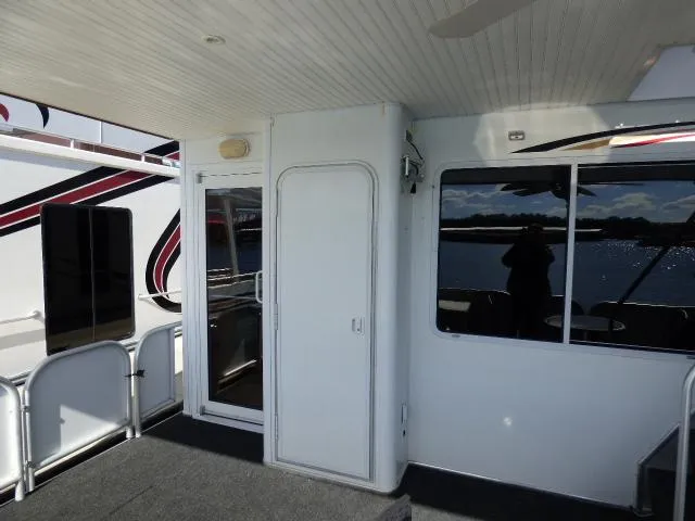 Slide: The Image of Interior view of a 2006 Thoroughbred 20x90 boat with white walls and large windows. - 14
