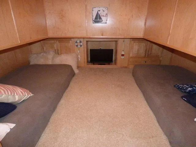 Slide: The Image of Cozy cabin interior with twin beds, wooden walls, and a small TV. Thoroughbred 20x90, 2006. - 9