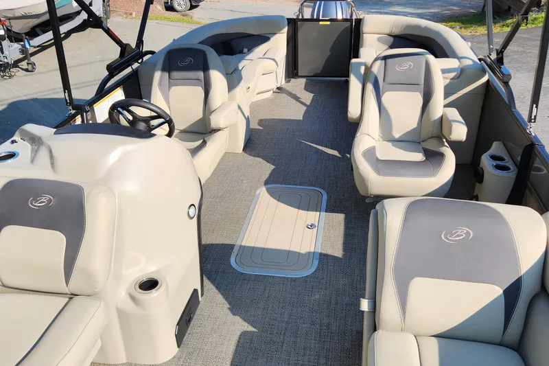 Slide: The Image of 2024 Barletta Aria 24QC pontoon boat interior with beige seating and steering console. - 6