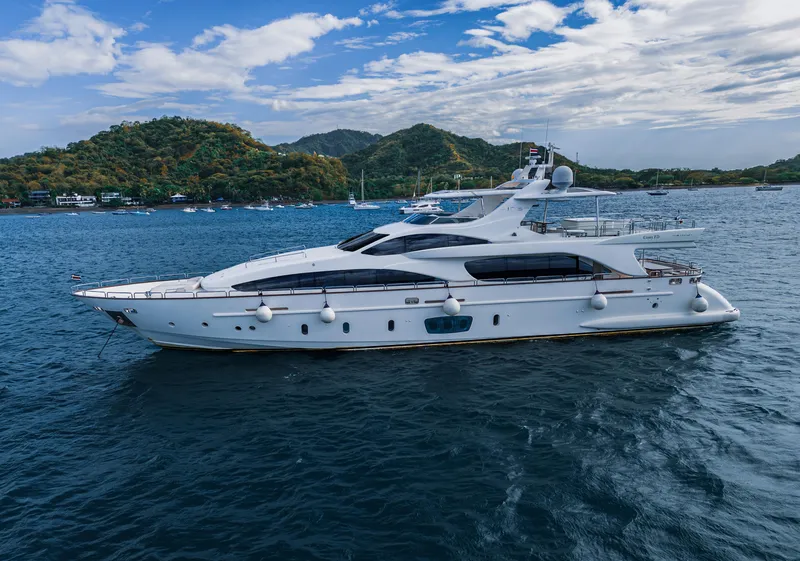 Slide: The Image of Luxurious 2006 Azimut 105 Grande yacht cruising on serene waters with scenic island backdrop. - 0