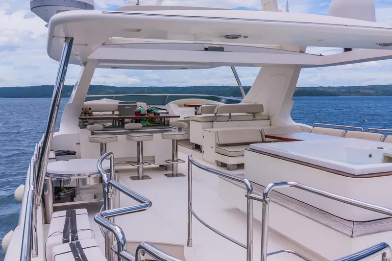 Slide: The Image of Luxurious 2006 Azimut 105 Grande yacht deck with bar and seating, overlooking serene ocean waters. - 34