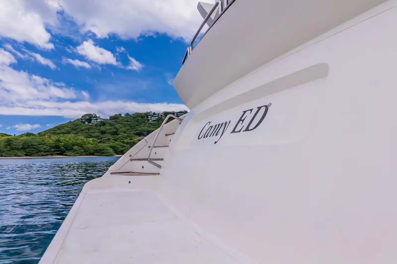 Slide: The Image of Luxury yacht Azimut 105 Grande, 2006 model, docked near lush green hills and blue sky. - 40