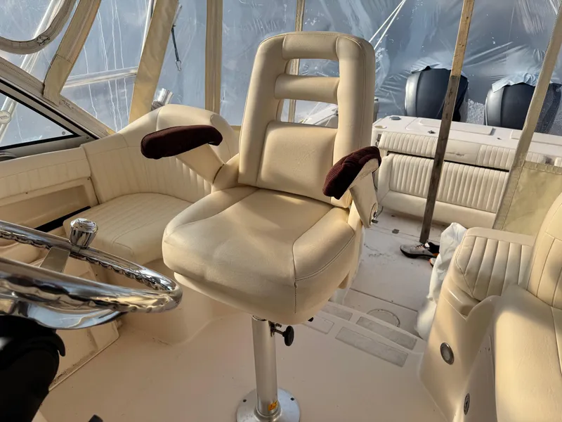Slide: The Image of Captain's chair in 2008 Grady-White Express 305 boat cockpit, featuring beige upholstery and steering wheel. - 10