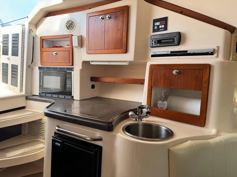 Slide: The Image of 2008 Grady-White Express 305 boat interior with kitchenette and wooden cabinets. - 13