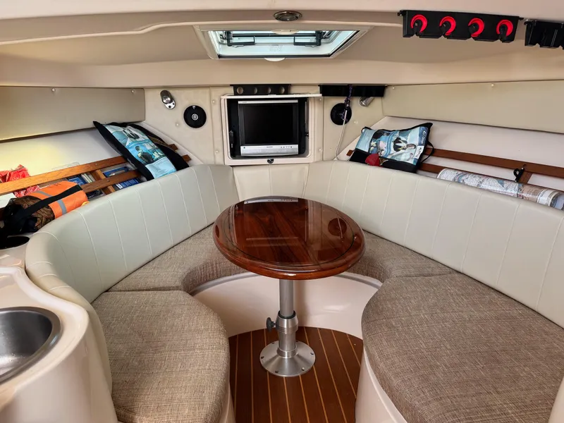 Slide: The Image of 2008 Grady-White Express 305 cabin interior with seating, table, and TV. - 14