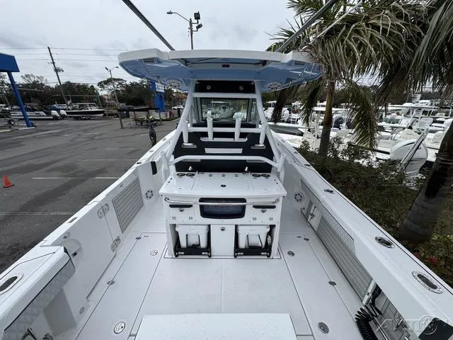 Slide: The Image of 2025 Blackfin 332cc boat, spacious deck, modern design, docked near palm trees. - 13
