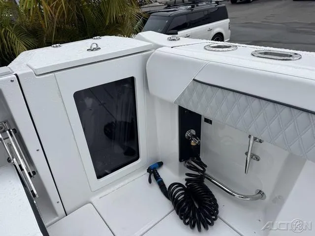 Slide: The Image of 2025 Blackfin 332cc boat deck with storage compartment and coiled hose. - 18