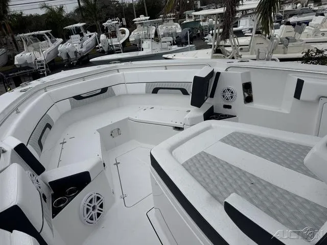 Slide: The Image of 2025 Blackfin 332cc boat interior with seating and cup holders, docked among other boats. - 27