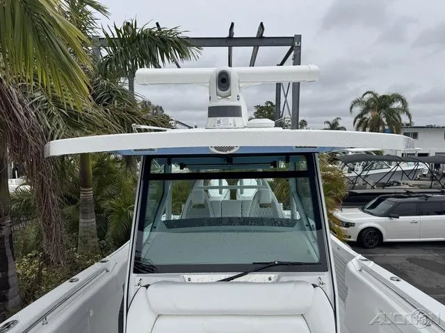 Slide: The Image of 2025 Blackfin 332cc boat with radar, docked near palm trees. - 33