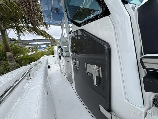 Slide: The Image of 2025 Blackfin 332cc boat, sleek design, white and black exterior, docked near palm trees. - 36