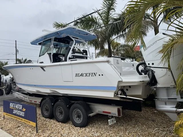 Slide: The Image of 2025 Blackfin 332cc boat on trailer, displayed at a dealership with palm trees. - 4