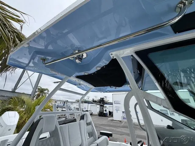 Slide: The Image of 2025 Blackfin 332cc boat with sleek design and modern seating under a blue canopy. - 40