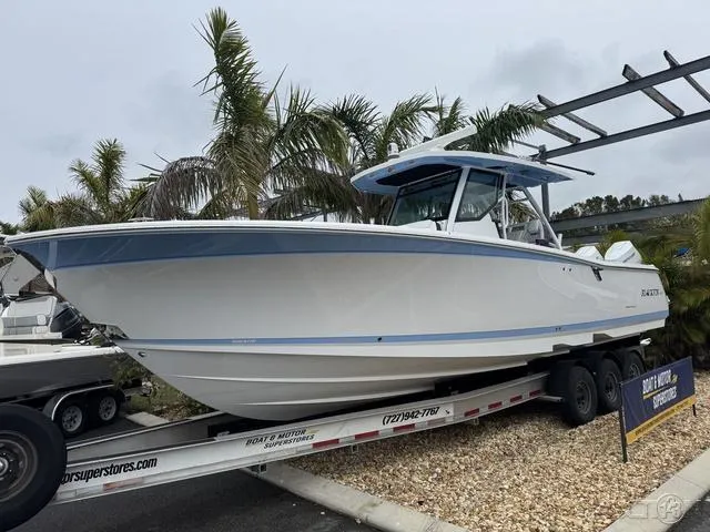 Slide: The Image of 2025 Blackfin 332cc boat on trailer, surrounded by palm trees. - 5