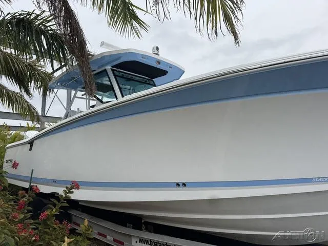 Slide: The Image of 2025 Blackfin 332cc boat on trailer, surrounded by palm trees. - 9