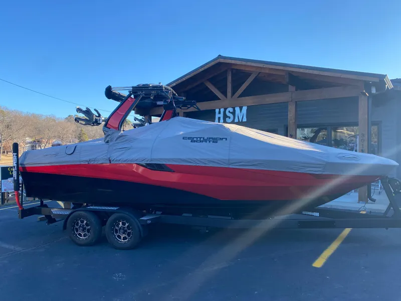Slide: The Image of 2023 Centurion Fi23 boat covered, parked on trailer outside HSM building. - 11