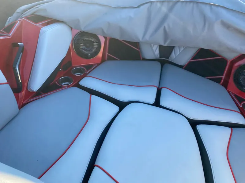 Slide: The Image of 2023 Centurion Fi23 boat interior with red and white cushioned seating and built-in speakers. - 15
