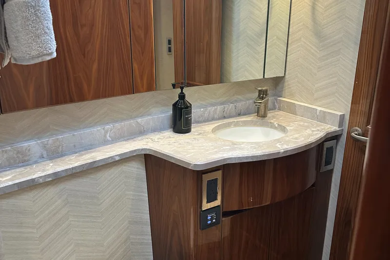 Slide: The Image of Luxurious bathroom vanity in 2017 Viking 55 Convertible yacht with marble countertop and wood accents. - 16
