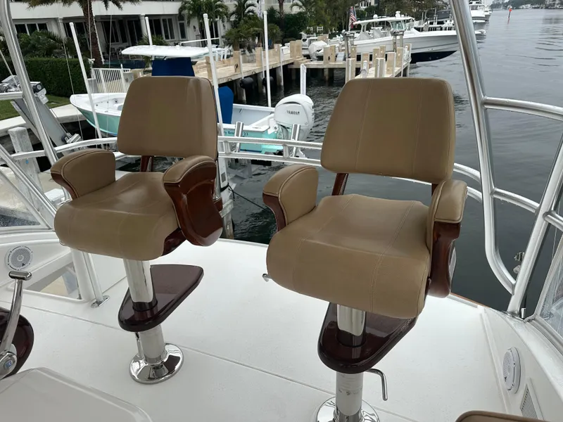 Slide: The Image of Two beige captain's chairs on a 2017 Viking 55 Convertible yacht deck. - 18