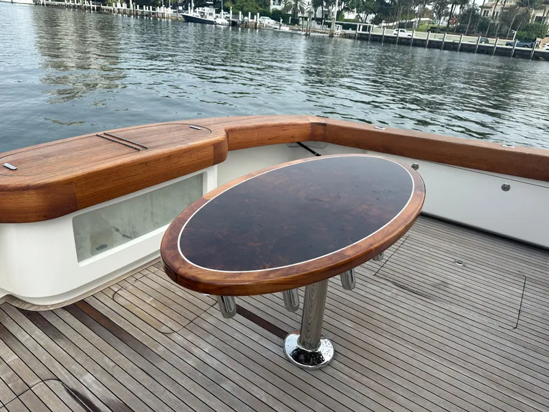 Slide: The Image of 2017 Viking 55 Convertible yacht deck with elegant wooden table and waterfront view. - 27