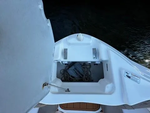 Slide: The Image of 2011 Yamaha SX240 HO boat anchor storage compartment open, showing anchor and rope. - 16
