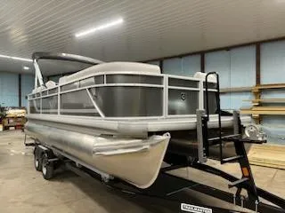The Image of 2024 Sweetwater 2286SBCX pontoon boat in indoor storage on trailer. - 0