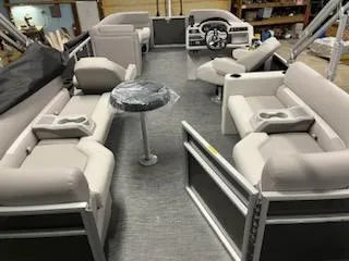 Slide: The Image of 2024 Sweetwater 2286SBCX pontoon boat interior with plush seating and steering console. - 11