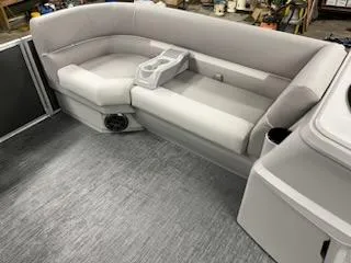 Slide: The Image of 2024 Sweetwater 2286SBCX boat interior with gray seating and cup holders. - 15