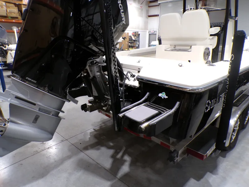 Slide: The Image of 2024 ShearWater 250 SS Carolina boat, rear view with motor and seating, in a garage. - 11