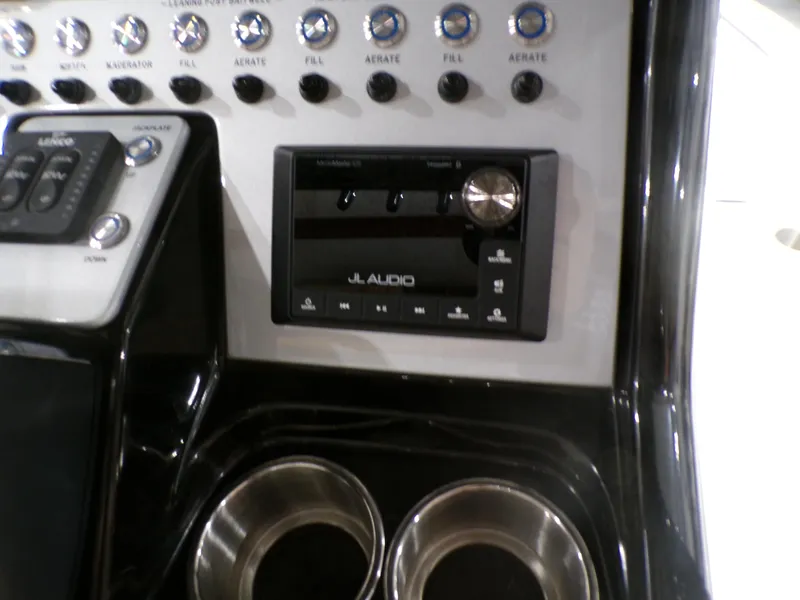 Slide: The Image of 2024 ShearWater 250 SS Carolina boat with black rod holders in a warehouse. - 24