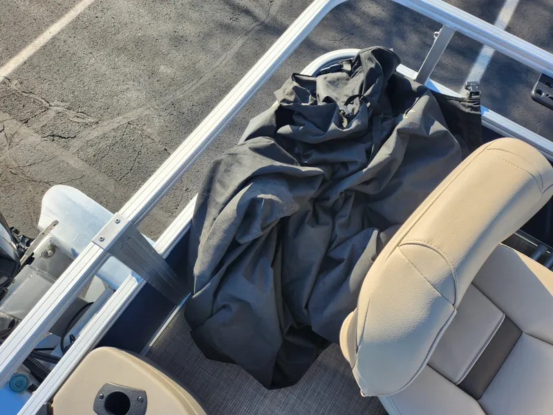 Slide: The Image of 2023 Sun Tracker Bass Buggy 18 DLX interior with beige seats and black cover. - 16