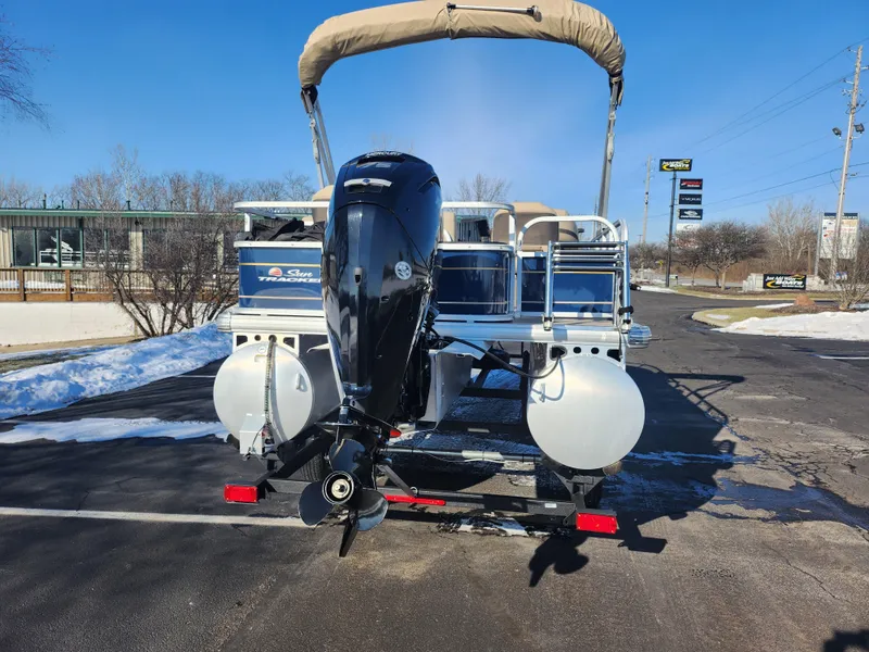 Slide: The Image of 2023 Sun Tracker Bass Buggy 18 DLX pontoon boat with outboard motor on trailer. - 2