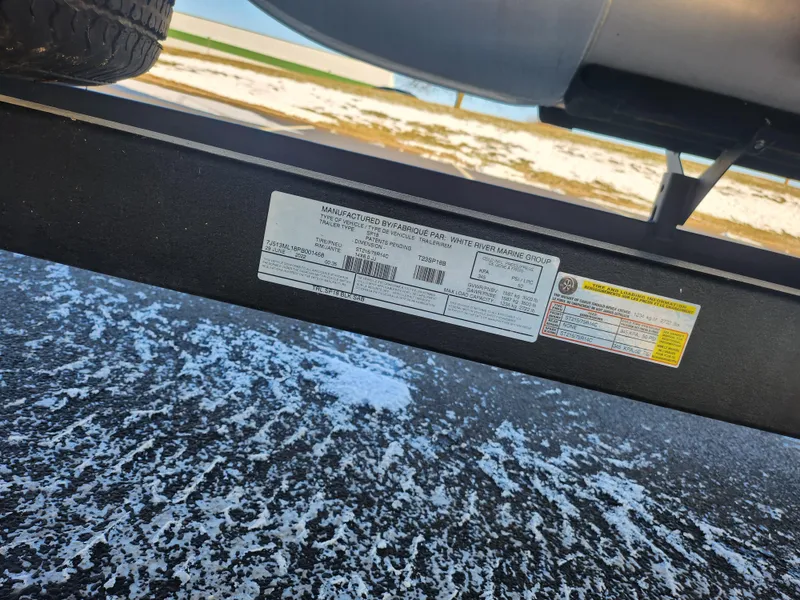 Slide: The Image of 2023 Sun Tracker Bass Buggy 18 DLX trailer label on snowy ground. - 27