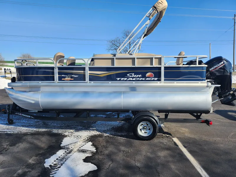Slide: The Image of 2023 Sun Tracker Bass Buggy 18 DLX pontoon boat on trailer in parking lot. - 4
