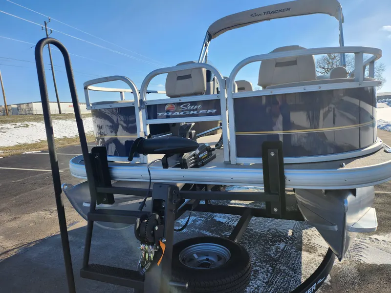 Slide: The Image of 2023 Sun Tracker Bass Buggy 18 DLX pontoon boat on trailer in parking lot. - 6