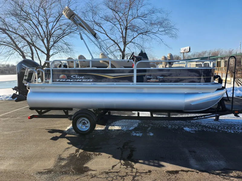 Slide: The Image of 2023 Sun Tracker Bass Buggy 18 DLX pontoon boat on trailer, parked in snowy lot. - 9